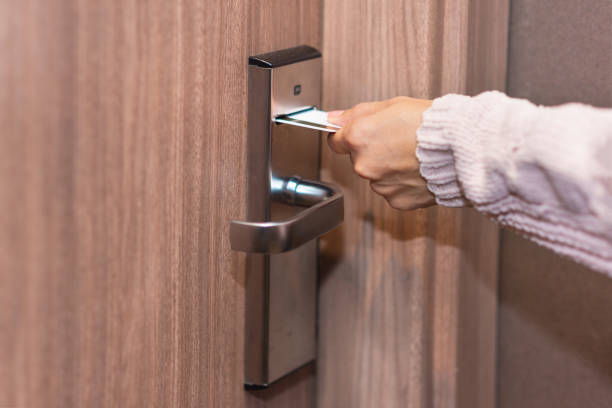 istock Woman hand inserting card to open electronic lock in hotel door 1074671646