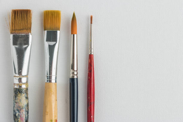 istock Artist paint brushes on canvas background 1074675582