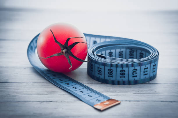 測定テープとジューシーなトマト、減量と健康的な栄養の概念 - instrument of measurement vegetable measuring exercising ストックフォトと画像