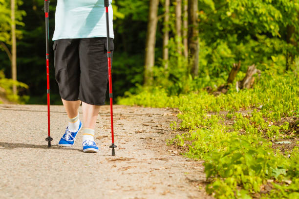 istock Senior woman practicing nordic walking in park 1074710144