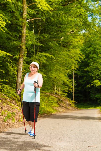 istock Senior woman practicing nordic walking in park 1074710168