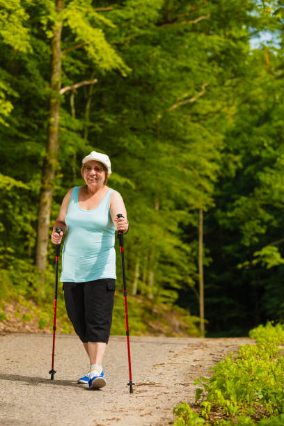 istock Senior woman practicing nordic walking in park 1074711548
