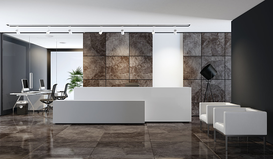 white reception desk with copy space in entrance area of an office building \nwith natural slate stone large brown veneer tiles. lobby area with two white \nleather armchairs in front of black wall and two white computer desks. \nwhite ceiling with white spotlights