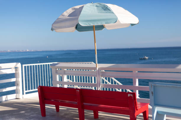 istock Red Bench with Pastel Blue Umbrella 1074732332