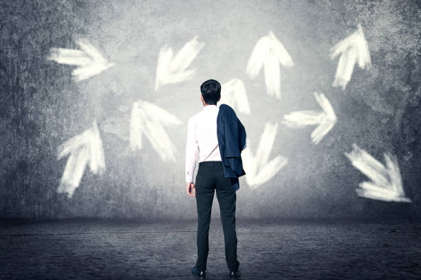 istock young man with arrow on wall background 1074737638