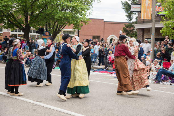 Holland, Michigan, United States-May 14,2017: Dutch style dancers in traditional outfits and clogs dancing during a public parade with spectators in downtown Holland, Michigan.