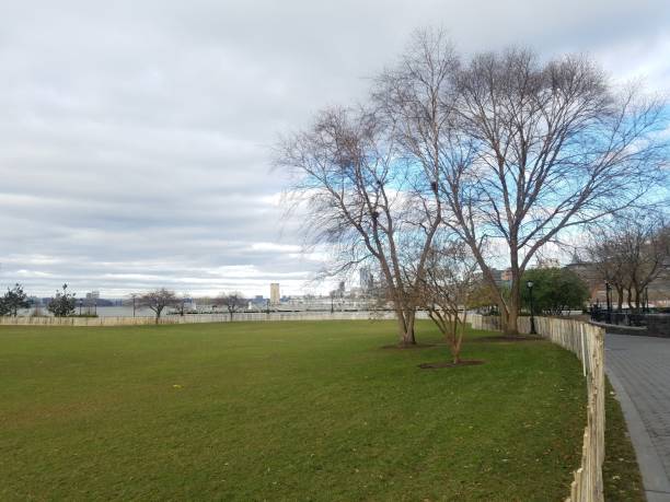 istock Large lawn in riverfront, Hudson River Park, lower Manhattan NYC, overlooking river and Jersey City skyline, NJ 1074753356