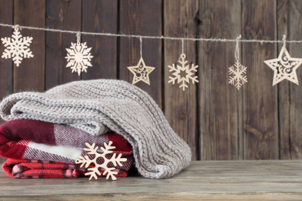 istock stack of plaids and Christmas decorations on wooden background 1074767378
