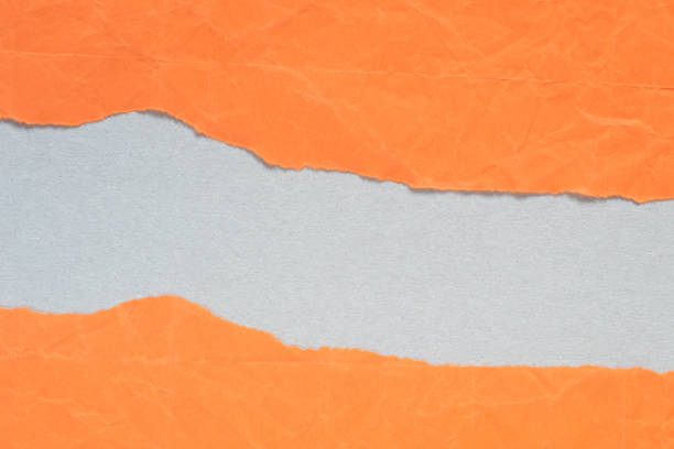 istock orange torn paper with copy space on gray background 1074780782