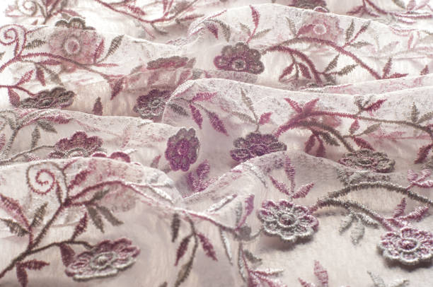 istock Texture, background, pattern. Pink lace decorated with flowers on a white background. Background of pink lace fabric beautifully decorated with flowers 1074787356