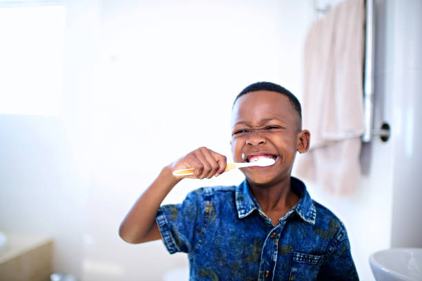 menino africano 6-7 anos escovando os dentes da frente sorrindo - 6 7 years fotos - fotografias e filmes do acervo