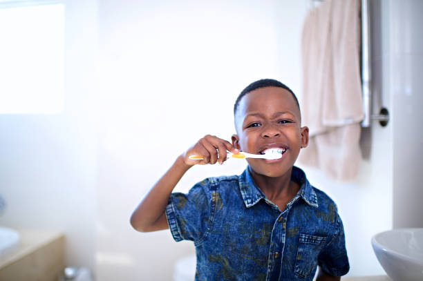 ragazzo africano di 6-7 anni che lava i denti anteriori - 6 7 years foto e immagini stock