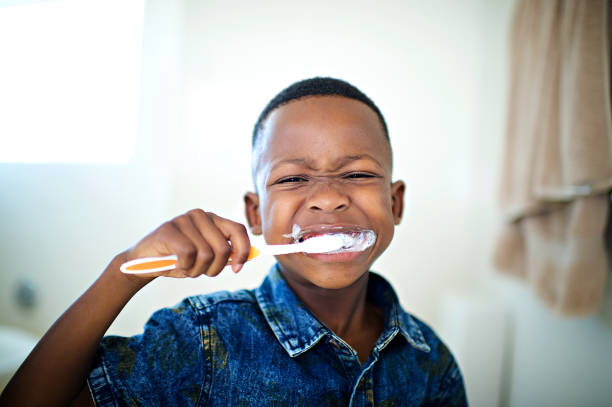 afrikanische 6-7 jahre alt junge putzen zähne nahaufnahme - child brushing human teeth brushing teeth stock-fotos und bilder