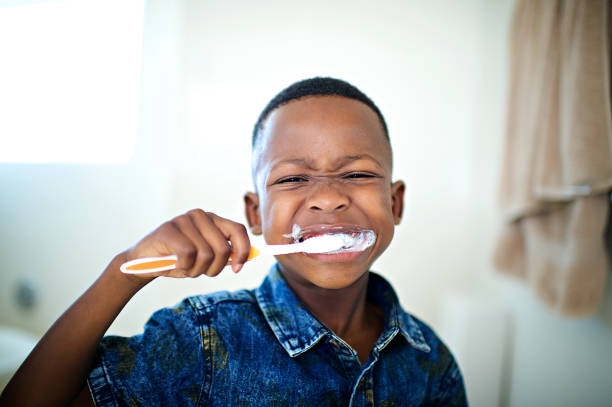 アフリカの 6 〜 7 歳男の子ブラッシング歯クローズ アップ - child brushing human teeth brushing teeth ストックフォトと画像