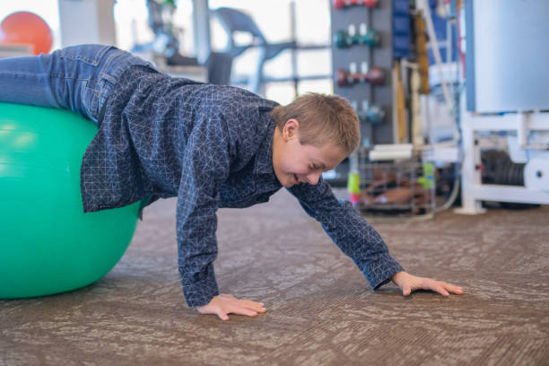 istock A boy does workouts with an occupational therapist at a physiotherapy clinic 1074805210