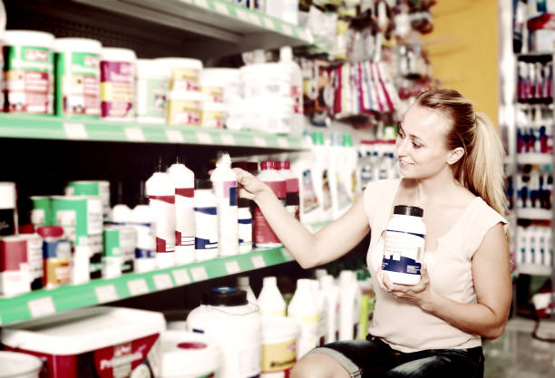 istock smiling young woman customer choosing paint medium in bottle in hypermarket 1074805644