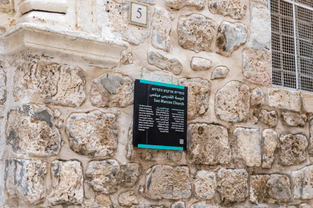 A sign with the inscription - St. Mark's Church - in three languages - Hebrew, Arabic and English near the entrance to the church in old city of Jerusalem, Israel Jerusalem, Israel, November 24, 2018 : A sign with the inscription - St. Mark's Church - in three languages - Hebrew, Arabic and English near the entrance to the church in old city of Jerusalem, Israel st markos church pic stock pictures, royalty-free photos & images
