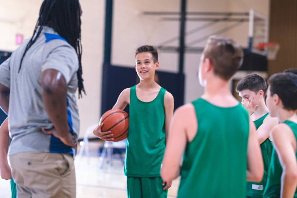 istock Coach talking with his elementary boy's basketball team 1074823278