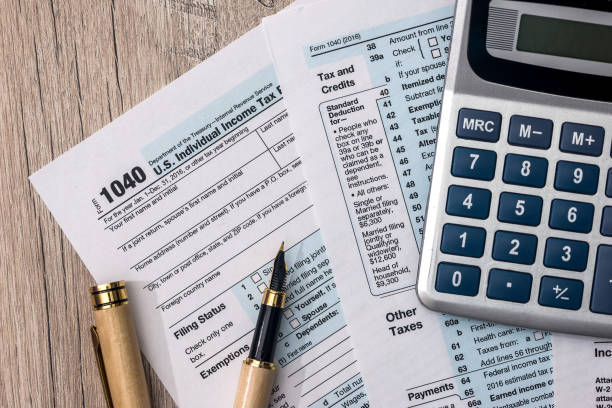 istock 1040 tax form with calculator and pen 1074834190