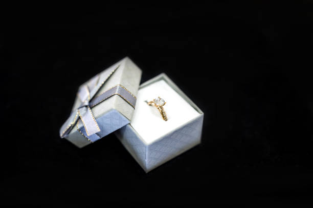 istock Golden ring in silver present box on black background 1074834480