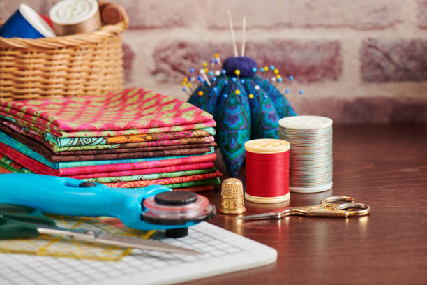 istock Stack of colorful fabrics on table surrounded by sewing accessories on brick wall background 1074836730