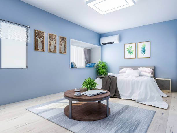 istock Spacious and unmanned bedroom design with solid wood custom closet and double bed in the blue walls, coffee table and decorations in front of the bed, TV, etc., green plants in the room 1074837456