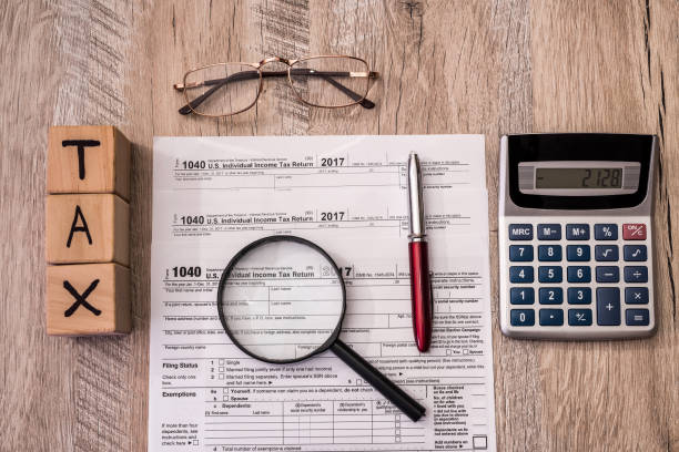 istock Tax form with cubes, calculator and magnifier 1074838916