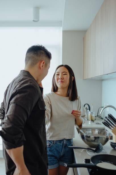 istock Asian couple cook together in kitchen 1074839346