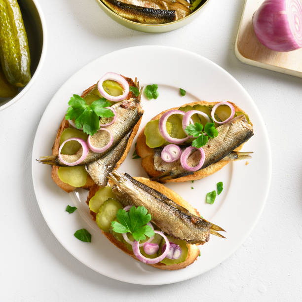 istock Sandwiches with sprats, marinated cucumber and onion 1074839786