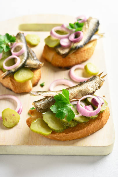 istock Sandwiches with sprats, marinated cucumber and onion 1074840168