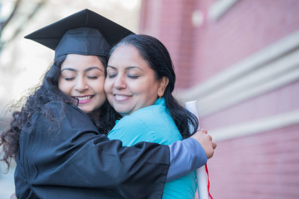 istock Happy young student hugs mother outside after graduation ceremony 1074846202