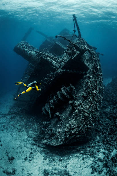 istock Scuba diver observing a large shipwreck completely rusted and overgrown lying underwater in the Red Sea 1074852610