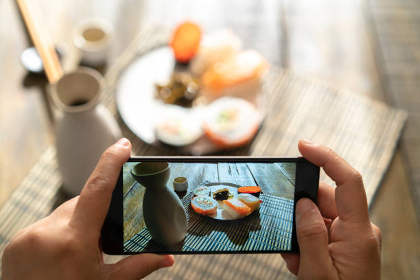 istock taking photo with mobile phone: Sushi and Saki 1074855310