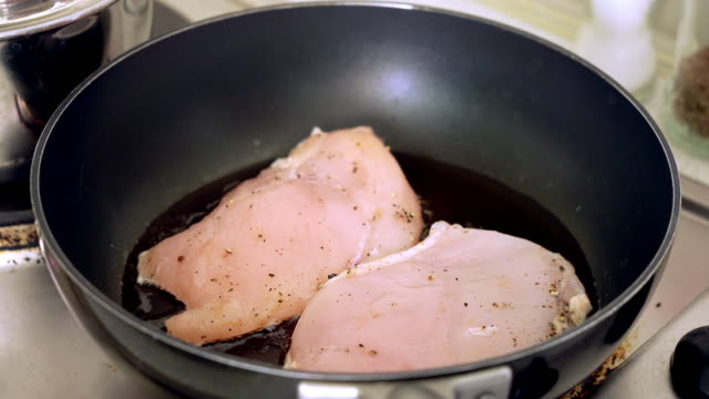 Cooking chicken breast grilled on pan.