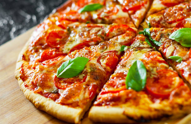 istock sliced Pizza with Mozzarella cheese, Tomatoes, pepper, Spices and Fresh Basil. Italian pizza. Pizza Margherita or Margarita 1074858856