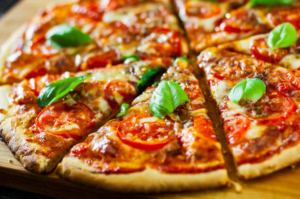istock sliced Pizza with Mozzarella cheese, Tomatoes, pepper, Spices and Fresh Basil. Italian pizza. Pizza Margherita or Margarita 1074858928