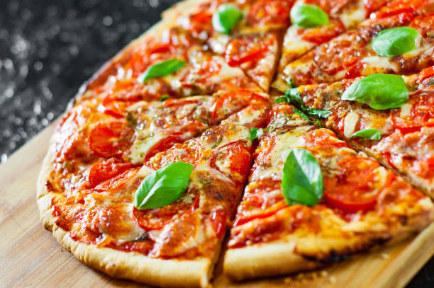 istock sliced Pizza with Mozzarella cheese, Tomatoes, pepper, Spices and Fresh Basil. Italian pizza. Pizza Margherita or Margarita 1074858930