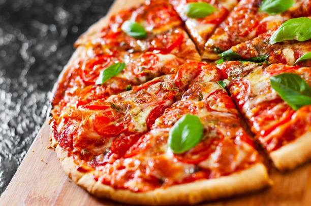 istock sliced Pizza with Mozzarella cheese, Tomatoes, pepper, Spices and Fresh Basil. Italian pizza. Pizza Margherita or Margarita 1074859020