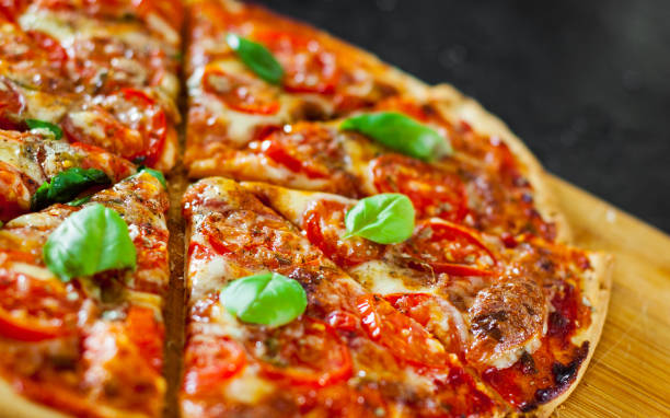 istock sliced Pizza with Mozzarella cheese, Tomatoes, pepper, Spices and Fresh Basil. Italian pizza. Pizza Margherita or Margarita 1074859690