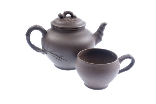 istock teapot on a white background Dark-red enameled pottery teapot on a white background 1074860162