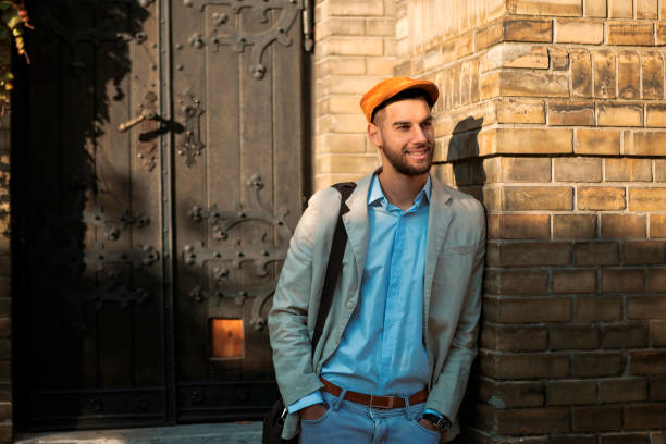 istock Young stylish man leaning on a brick wall 1074861936