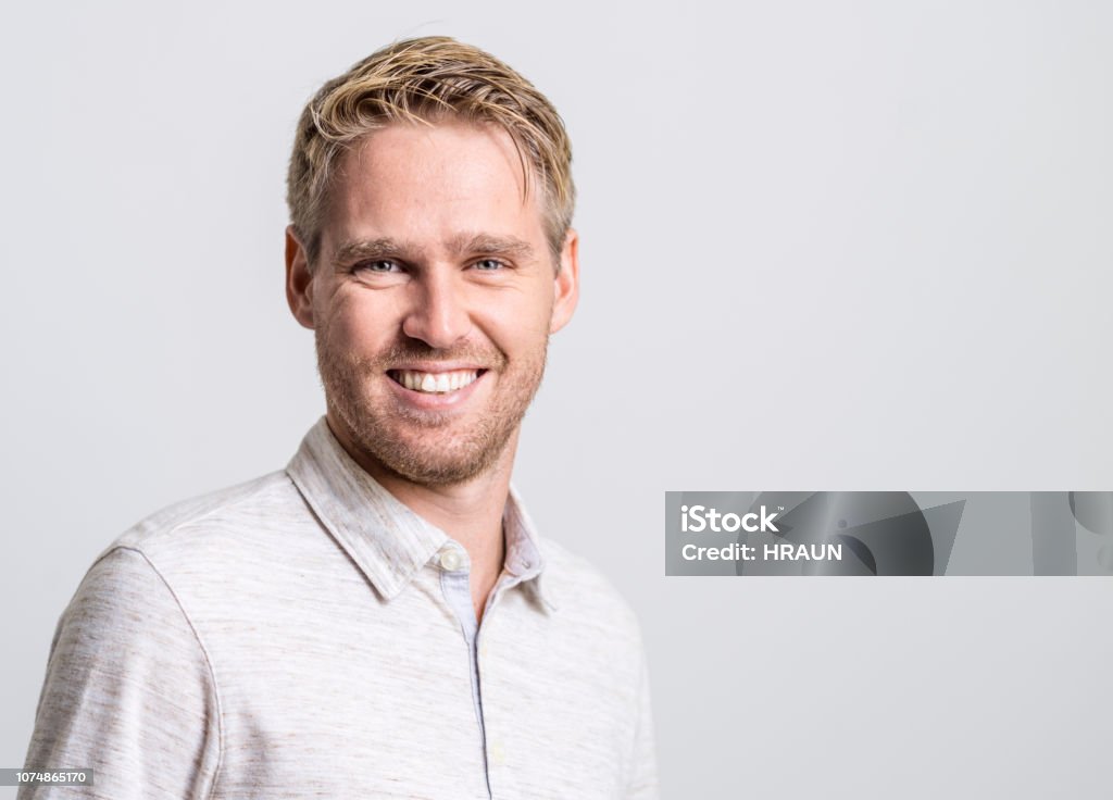 Portrait of smiling young man Portrait of smiling young man. Close-up of creative male professional is against white background. He is wearing smart casuals. Blond Hair Stock Photo