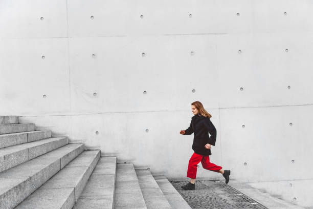 istock Woman running up steps in urban setting 1074874758