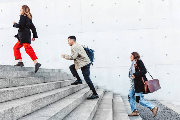 istock friends running up steps in urban setting 1074874810
