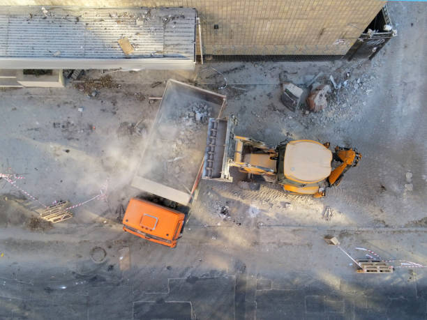 istock Bulldozer loader uploading waste and debris into dump truck at construction site. building dismantling and construction waste disposal service. Aerial drone industrial background 1074882194