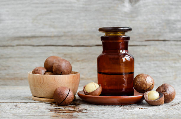 istock Pharmacy bottle with macadamia nut oil and macadamia nuts. Old wooden background. Copy space. 1074885250