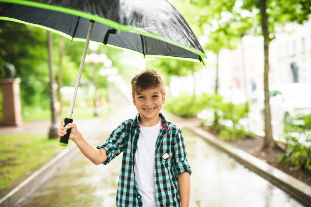 istock Cute boy, walking in a park on a rainy day 1074886680