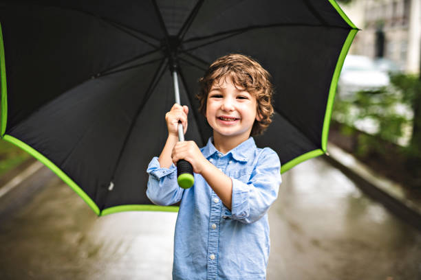 istock Cute boy, walking in a park on a rainy day 1074886822