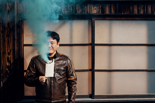 Mid adult man holding a smoldering coffee cup with smoke pouring out