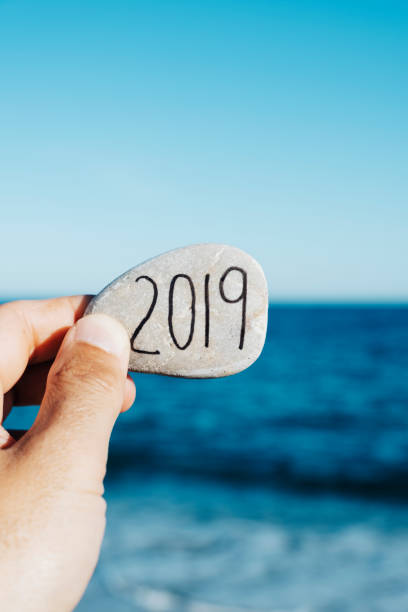 istock man holding a stone with the number 2019 1074887968